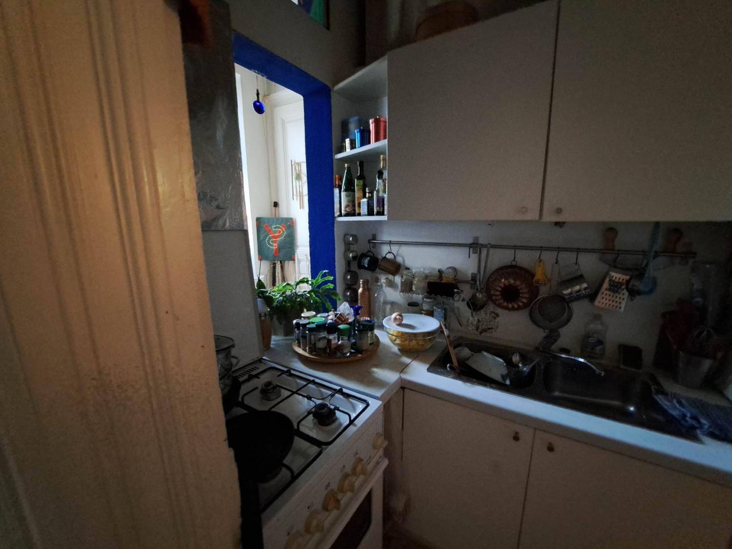 Nahaufnahme der Küche mit Gasherd, Spüle und Gewürzen auf der Arbeitsplatte, praktisch eingerichtet.
