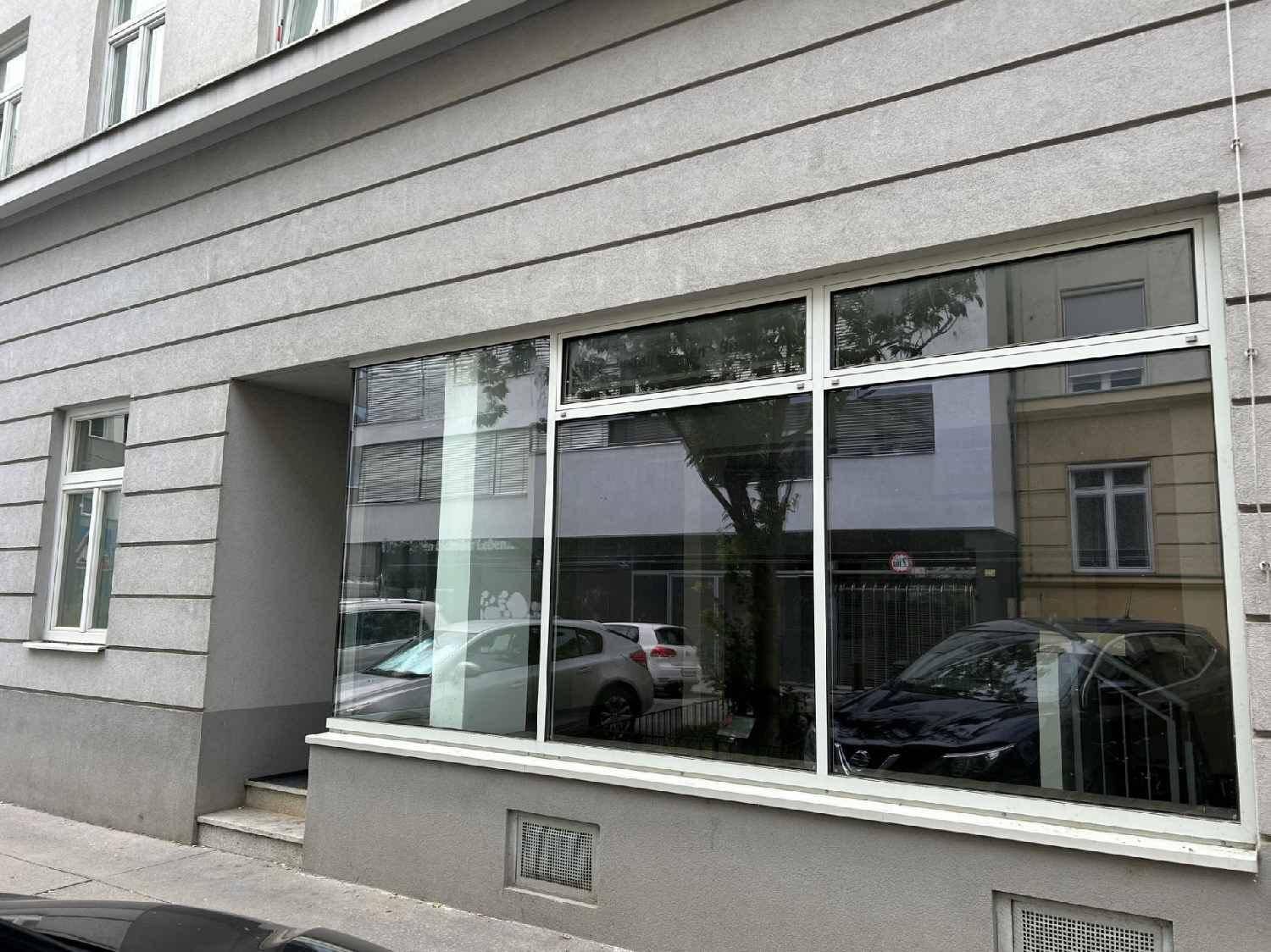 Fassade des Erdgeschosses mit großen Schaufenstern, die den Blick auf die Straße freigeben.