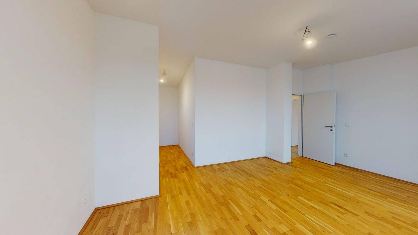 Heller Flurbereich mit Holzboden und Zugang zu weiteren Räumen der Wohnung.