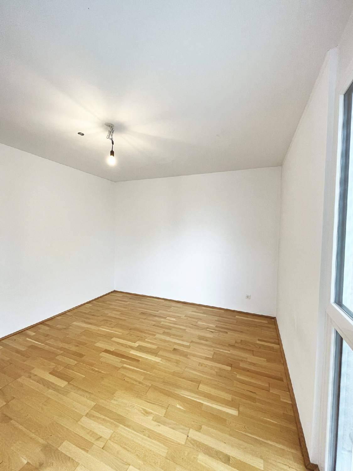 Leeres Zimmer mit hellem Parkettboden und Fenster, ideal als Schlaf- oder Arbeitszimmer nutzbar.
