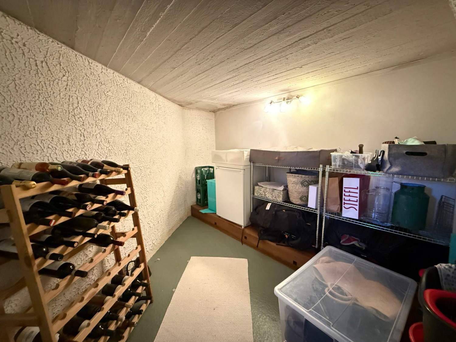Weinkeller mit Holzregalen für Flaschen und zusätzlichem Stauraum.