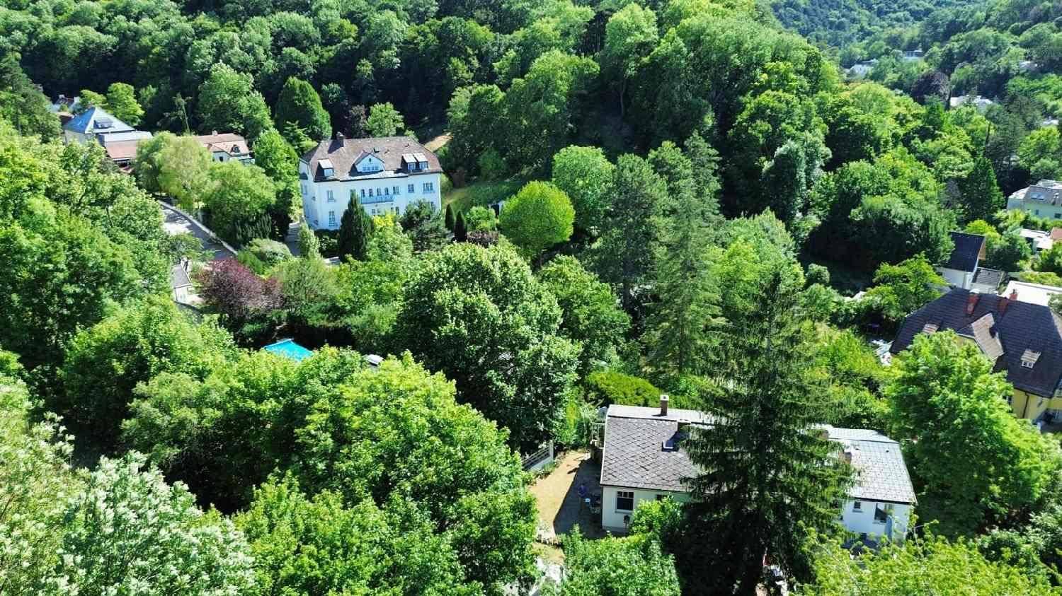 Luftaufnahme der Liegenschaft und der Umgebung, eingebettet in eine grüne Waldlandschaft.