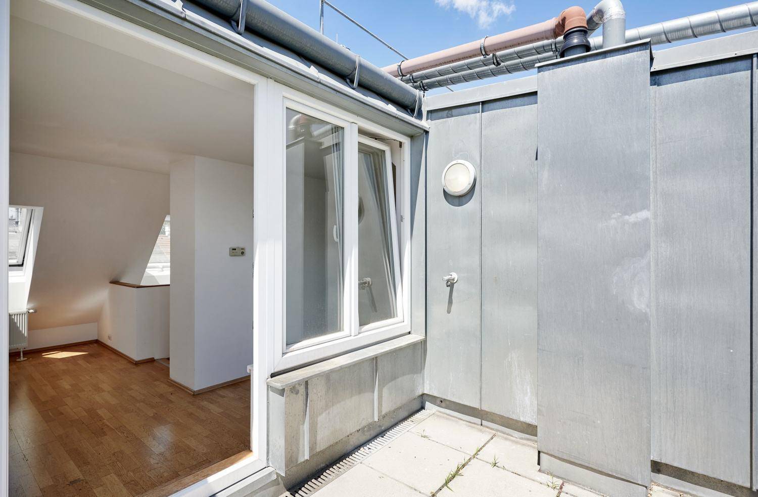 Zugang zum kleinen Balkon vom Innenraum, mit Blick auf die umliegenden Gebäude.