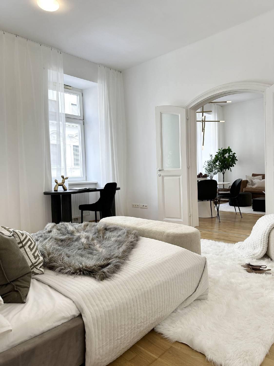 Helles Schlafzimmer mit Fenster und offenem Zugang zum Wohnbereich, der viel natürliches Licht bietet.