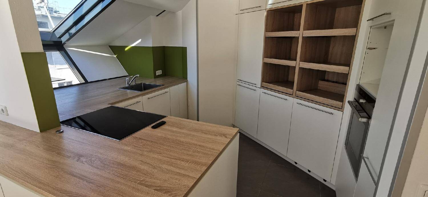 Moderne Küche mit Holztheke und integriertem Kochfeld, ergänzt durch offene Regale und grüne Akzente.