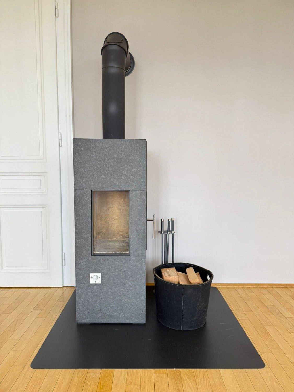 Moderner Kaminofen mit Holzscheiten, der eine gemütliche Atmosphäre schafft.