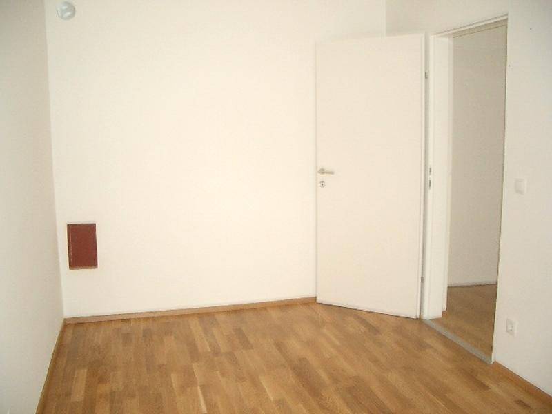 Leerer Raum mit Parkettboden und offener Tür, ideal für Schlaf- oder Arbeitszimmer.