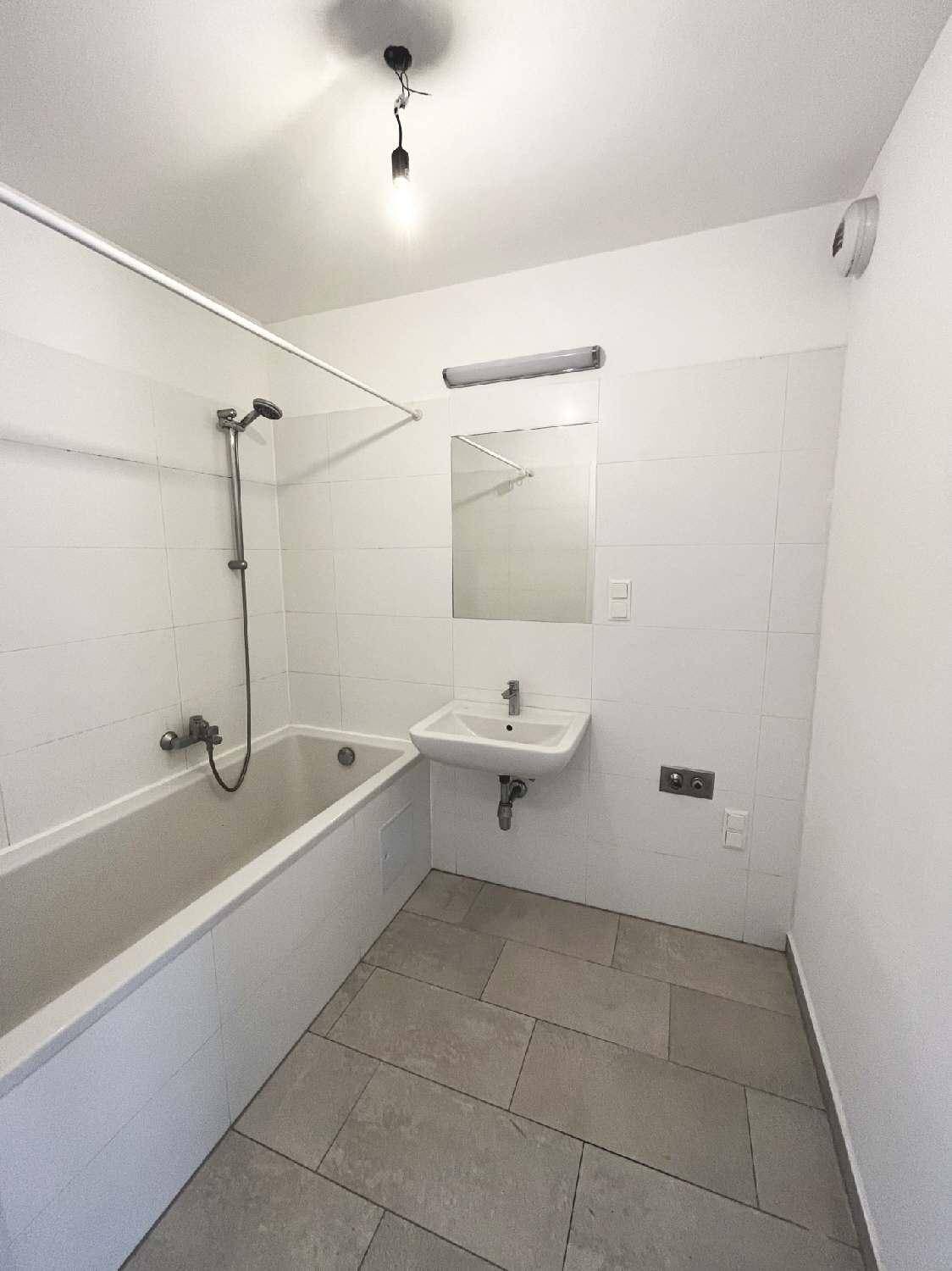Funktionales Badezimmer mit Badewanne, Waschbecken und hellen Fliesen.