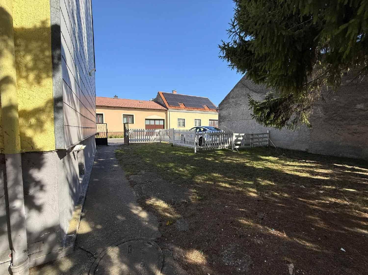 Seitlicher Gartenbereich mit Rasenfläche und Blick auf die Nachbarhäuser.