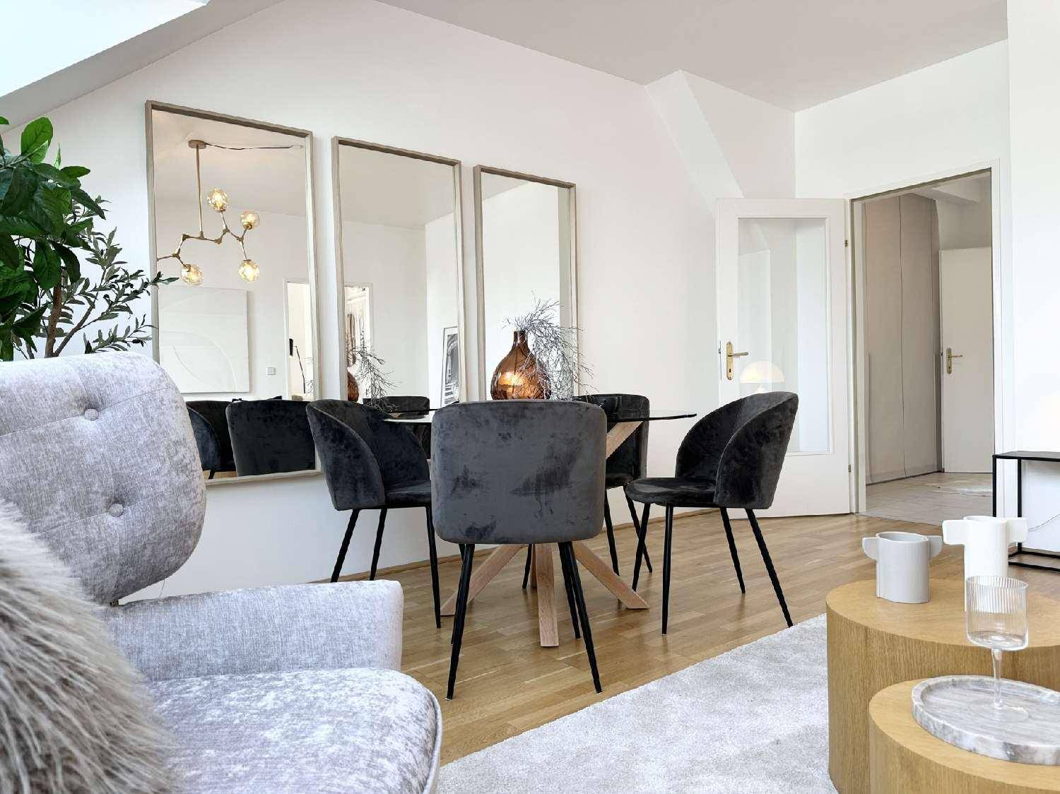 Eleganter Essbereich mit rundem Tisch, Samtstühlen und dekorativen Wandspiegeln.