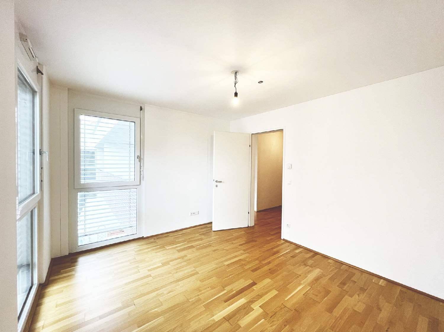 Helles Schlafzimmer mit Parkettboden und großem Fenster, bereit zur individuellen Einrichtung und Gestaltung.