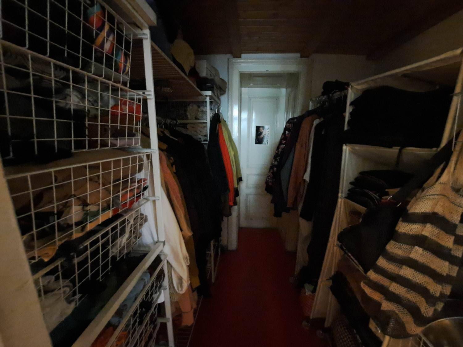 Praktischer Abstellraum mit Regalen und Kleiderstangen für zusätzlichen Stauraum und Organisation.