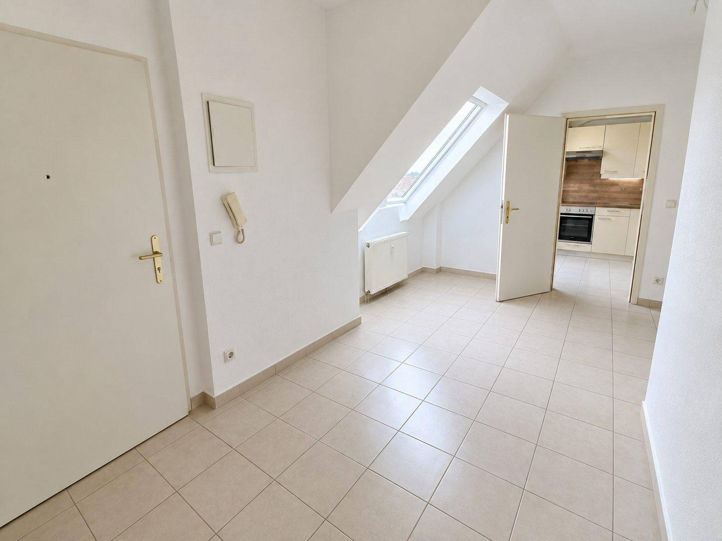 Heller Flurbereich mit Fliesenboden, Dachfenster und Zugang zu den angrenzenden Zimmern.
