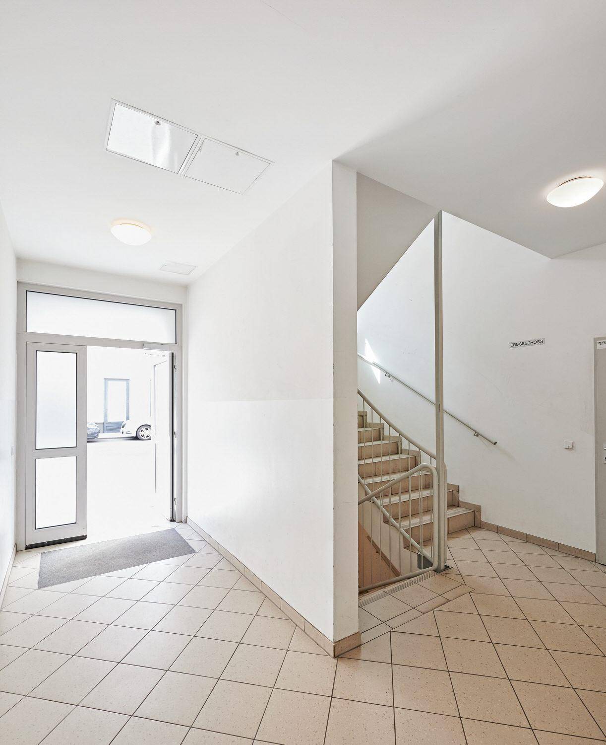 Geräumiger Eingangsbereich mit Treppenhaus und Fliesenboden.