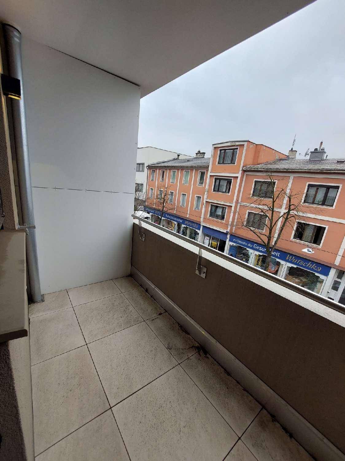 Kleiner Balkon mit Fliesenboden und Blick auf die gegenüberliegenden Gebäude.