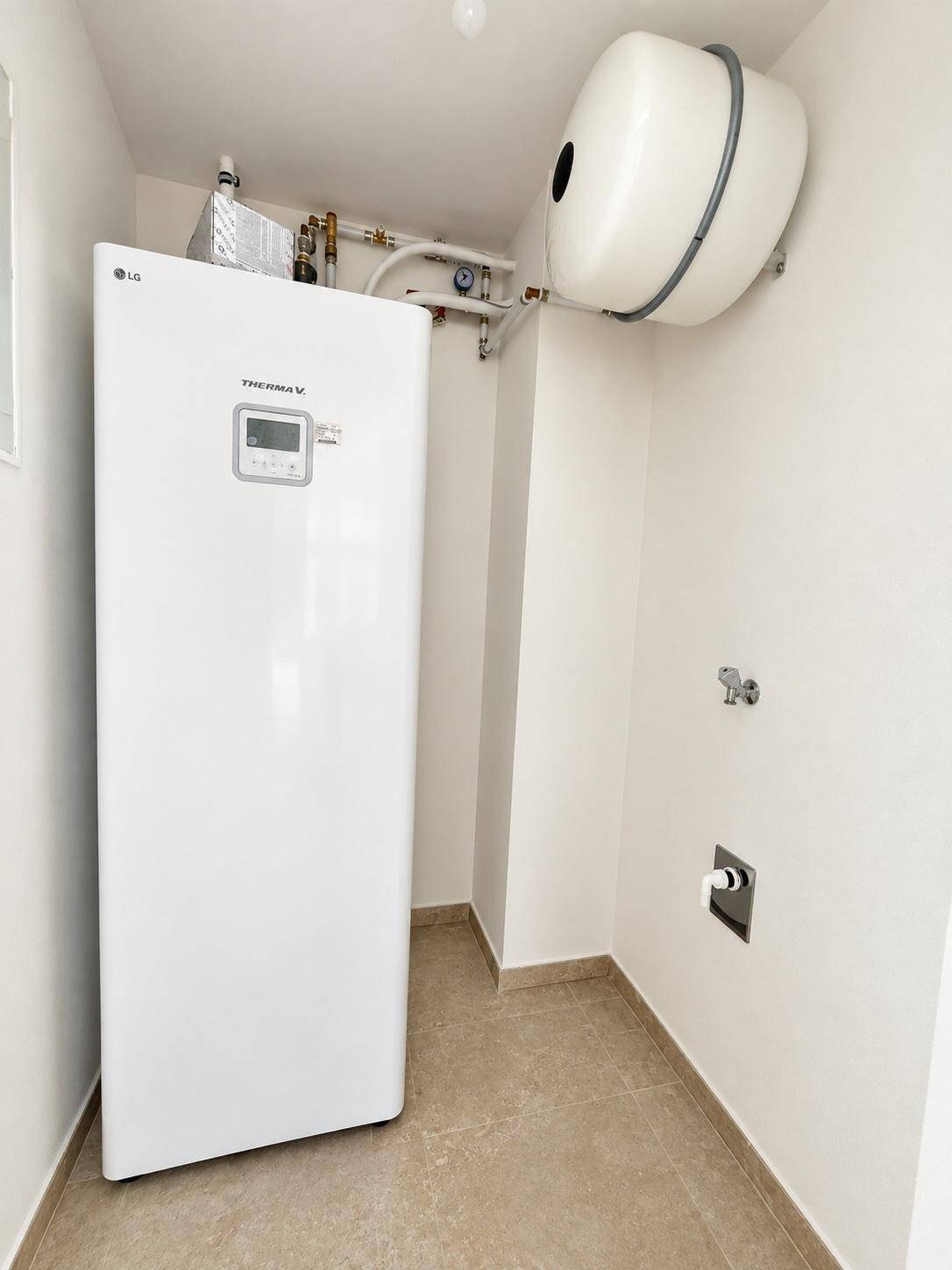 Technikraum mit moderner Wärmepumpe und Warmwasserspeicher.