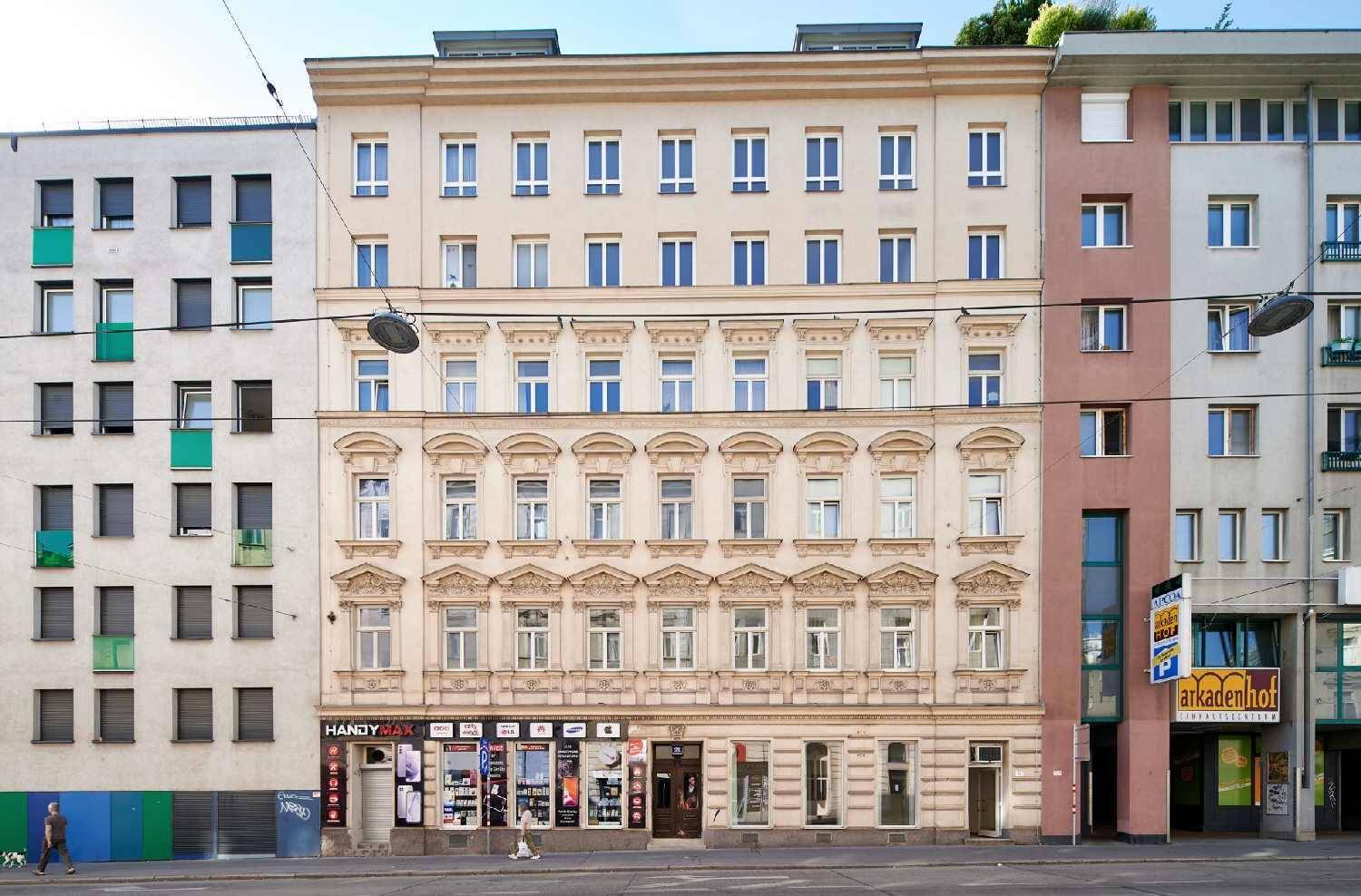 Ansicht der historischen Fassade eines Mehrfamilienhauses mit Geschäften im Erdgeschoss.