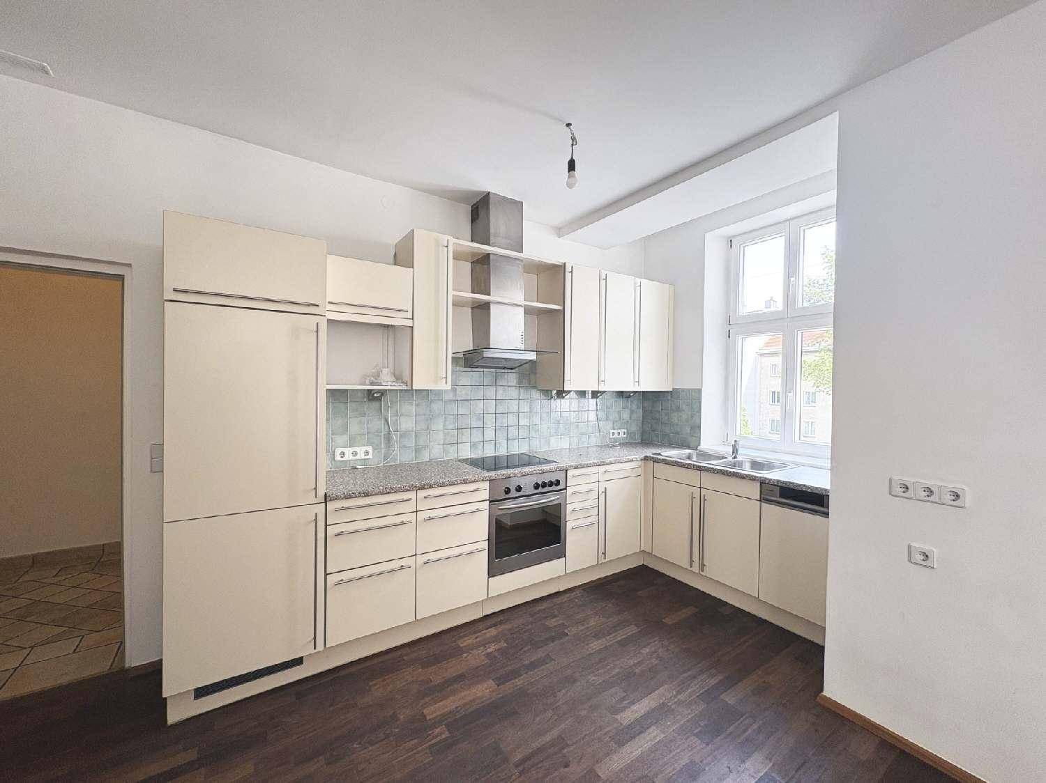 Funktionale Einbauküche mit hellen Schränken, Granitarbeitsplatte und Fenster für natürliches Licht.