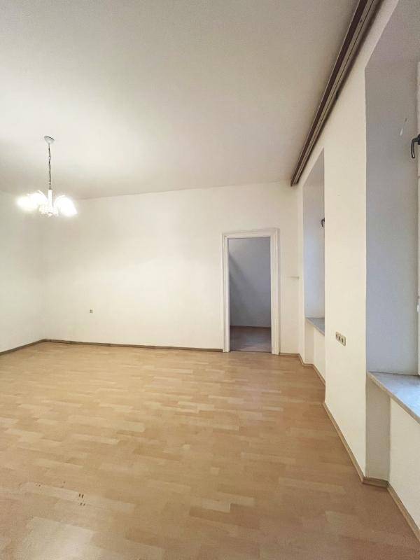 Geräumiges, helles Zimmer mit Parkettboden und tiefen Fensternischen, bietet viel Licht.