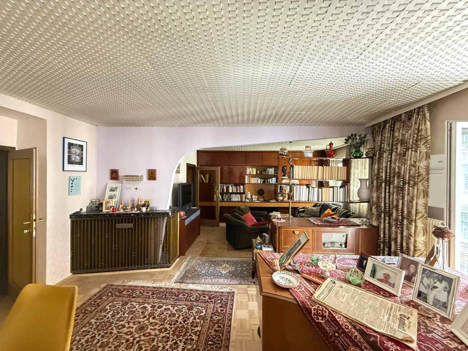 Geräumiger Wohn- und Essbereich mit traditionellen Möbeln, Bücherregalen und einem Essbereich.