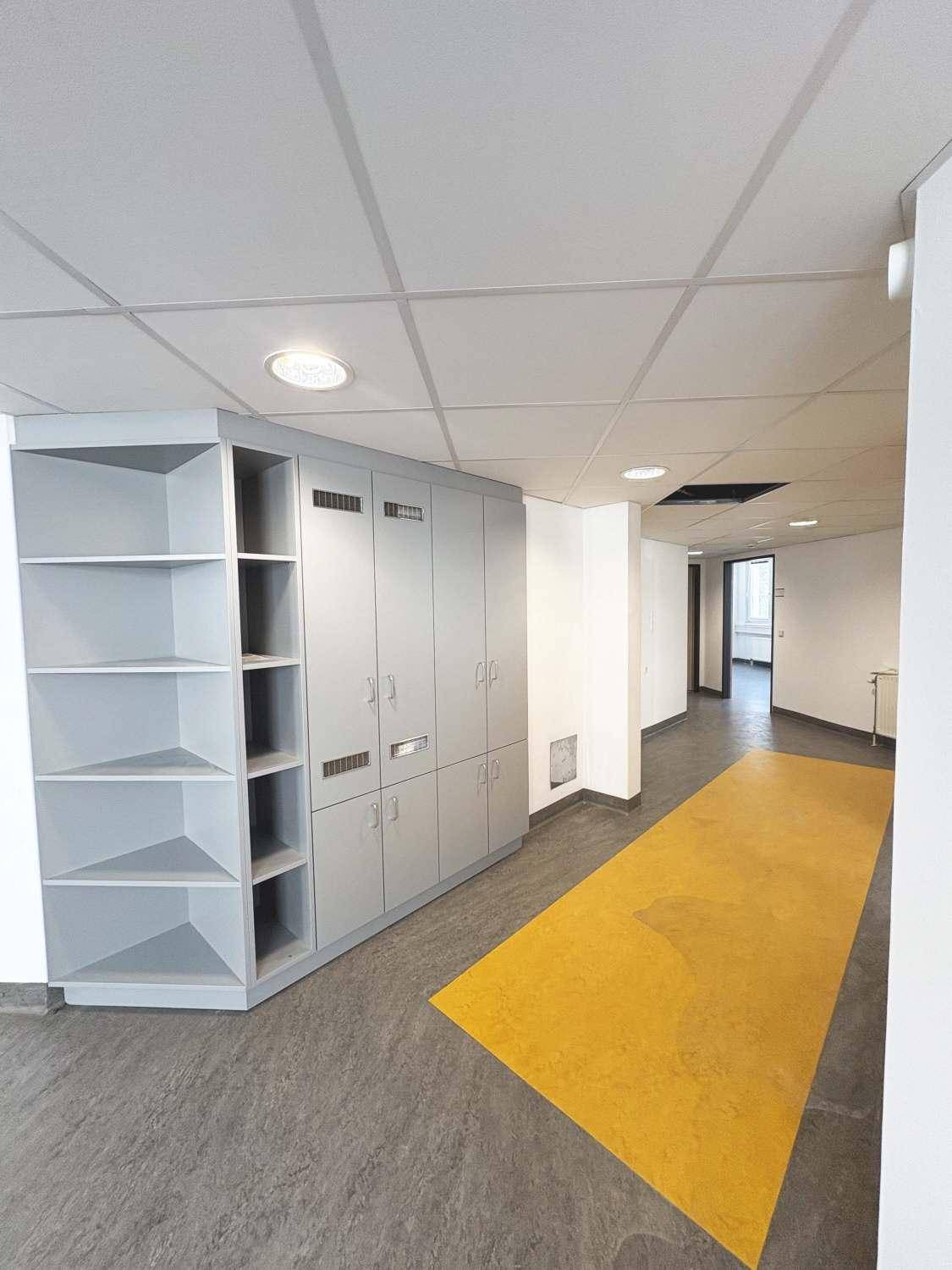 Flur mit grauem und gelbem Bodenbelag, sowie einem großen grauen Einbauschrank.