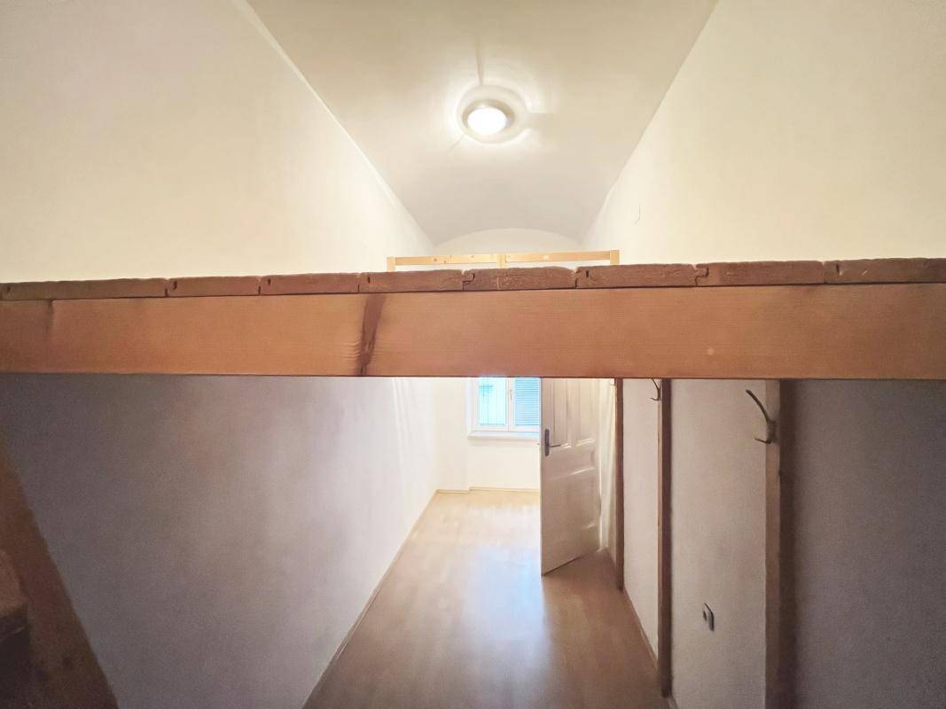 Flur mit hoher Decke und einer Holzkonstruktion für ein Hochbett oder eine Galerie.