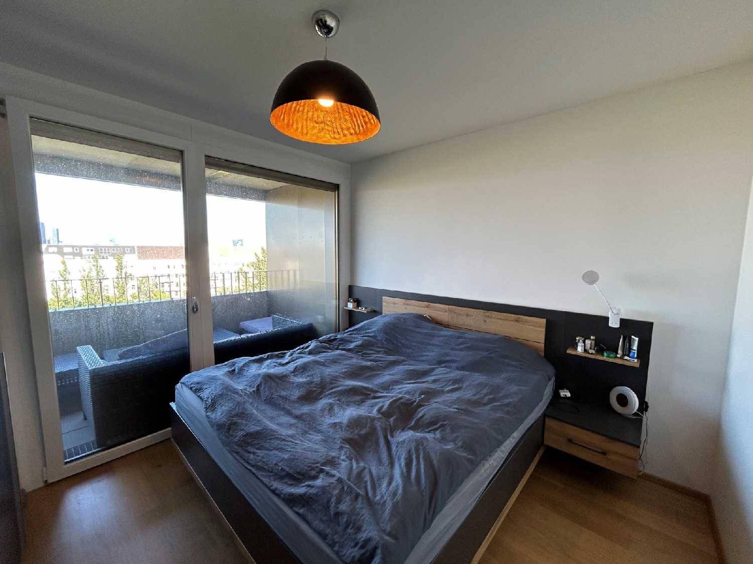 Helles Schlafzimmer mit Balkonzugang, Doppelbett und modernen Nachttischen.