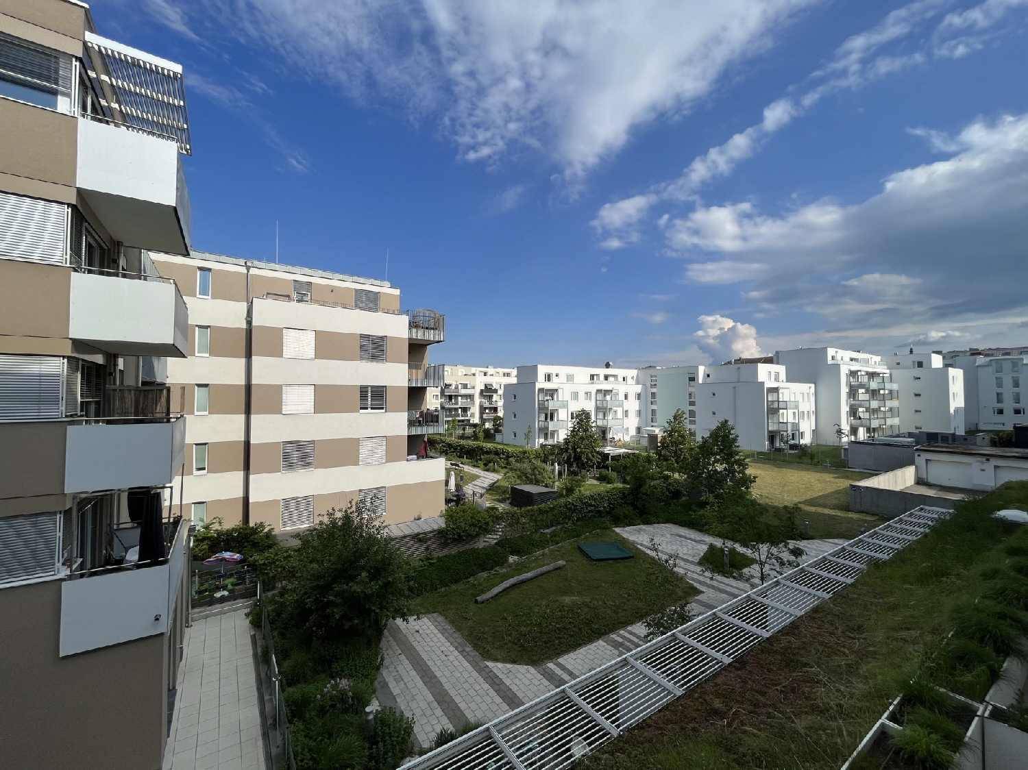 Blick auf die moderne Wohnanlage mit mehreren Gebäuden und begrünten Innenhöfen.