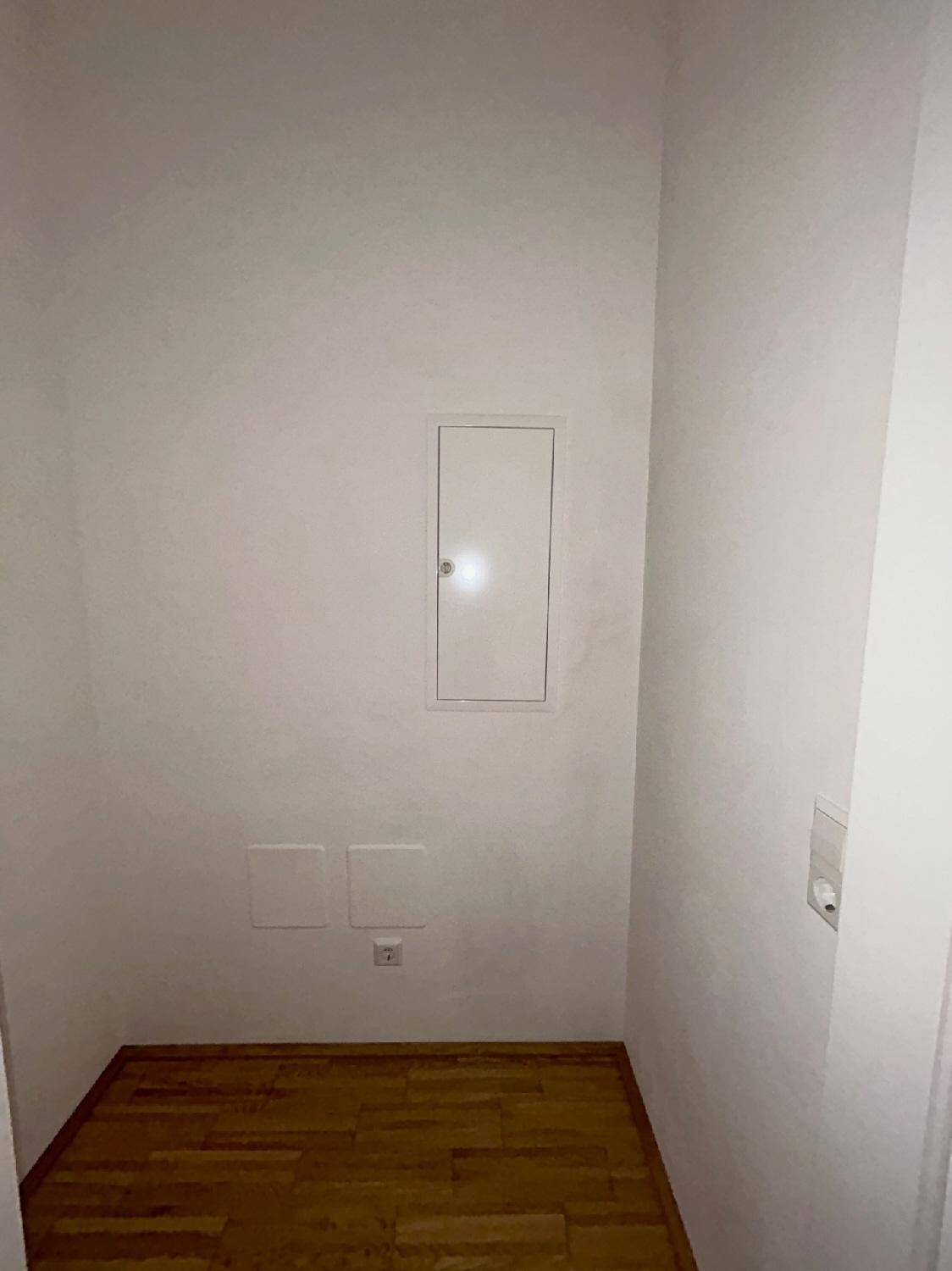 Kleiner Abstellraum mit Sicherungskasten und Parkettboden, bietet zusätzlichen Stauraum.