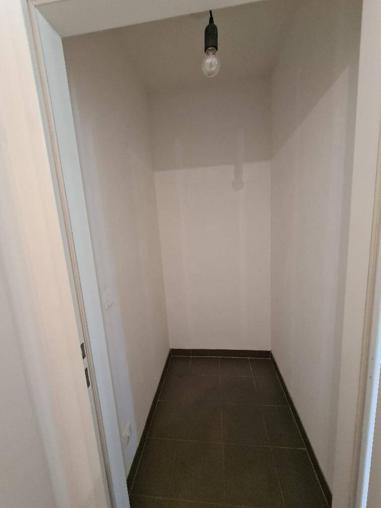 Kleiner Abstellraum mit dunklen Fliesen, ideal für zusätzlichen Stauraum.