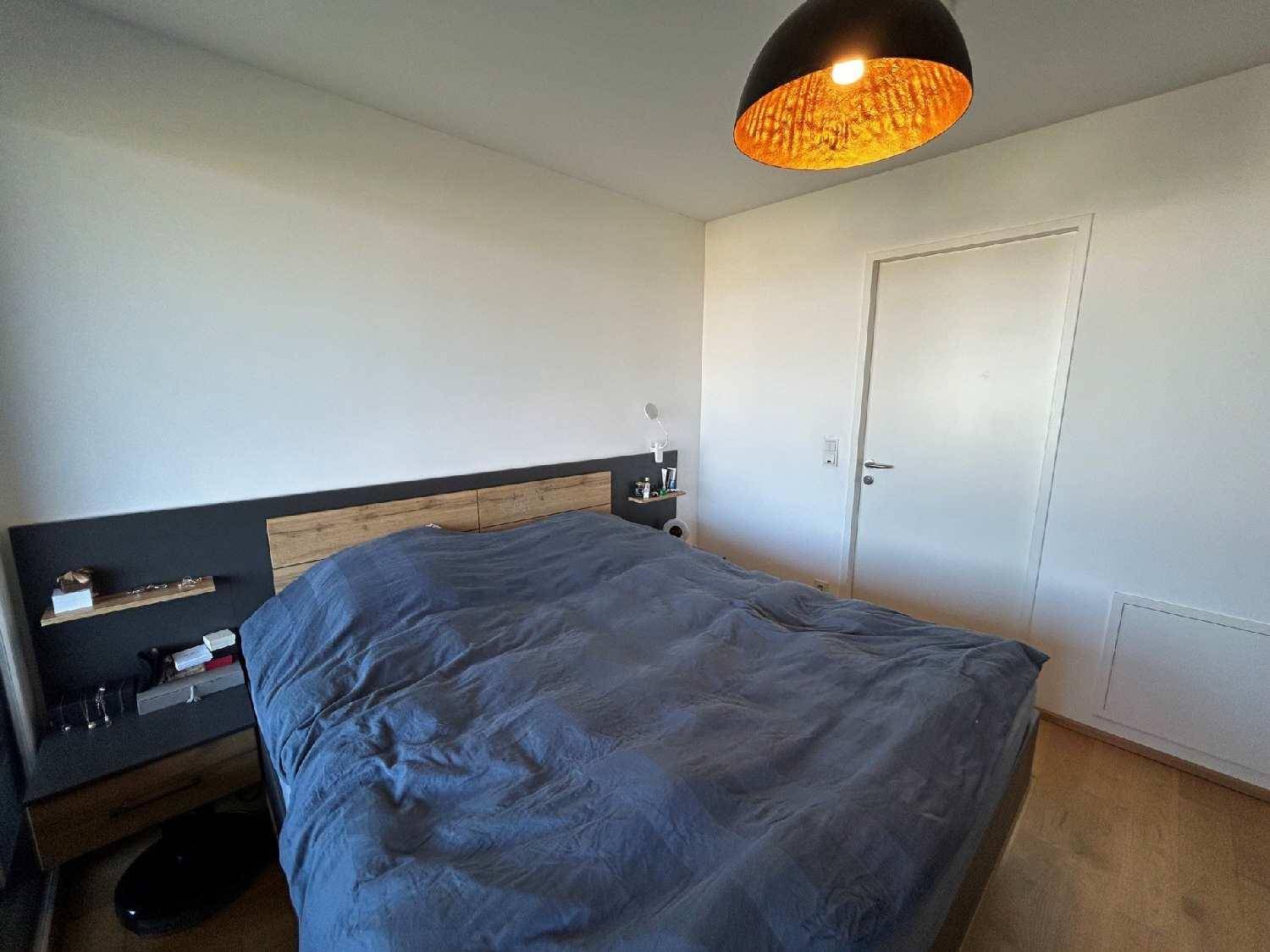 Schlafzimmer mit Doppelbett, integrierten Nachttischen und schlichtem Design.
