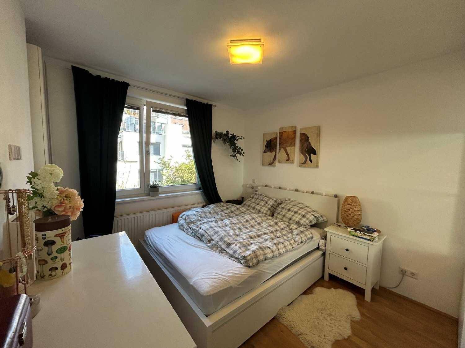 Schlafzimmer mit Doppelbett, Holzfußboden und einem Fenster mit Blick nach draußen.