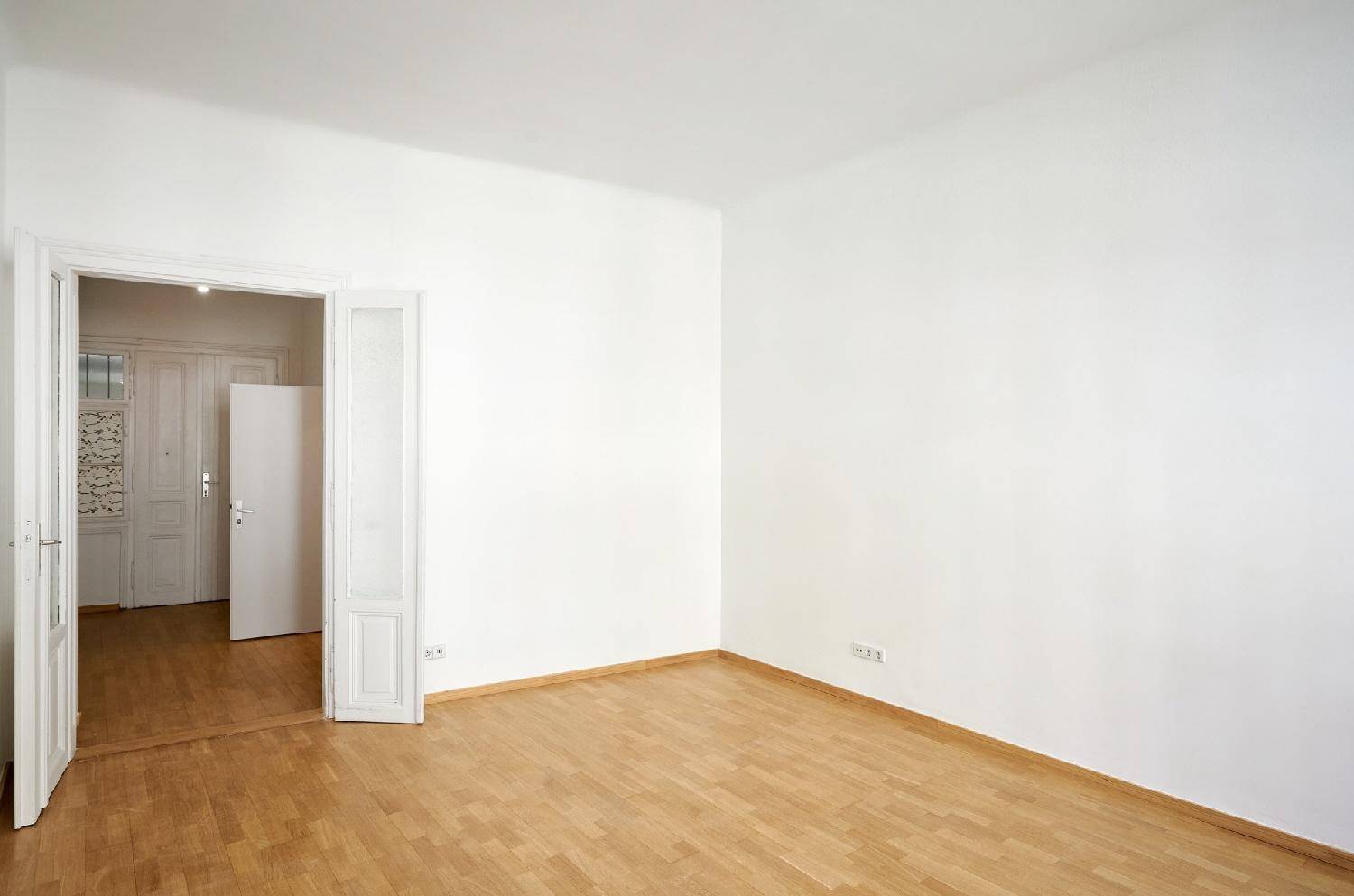 Heller Raum mit Parkettboden und offener Tür zu einem weiteren Bereich, vielseitig nutzbar.