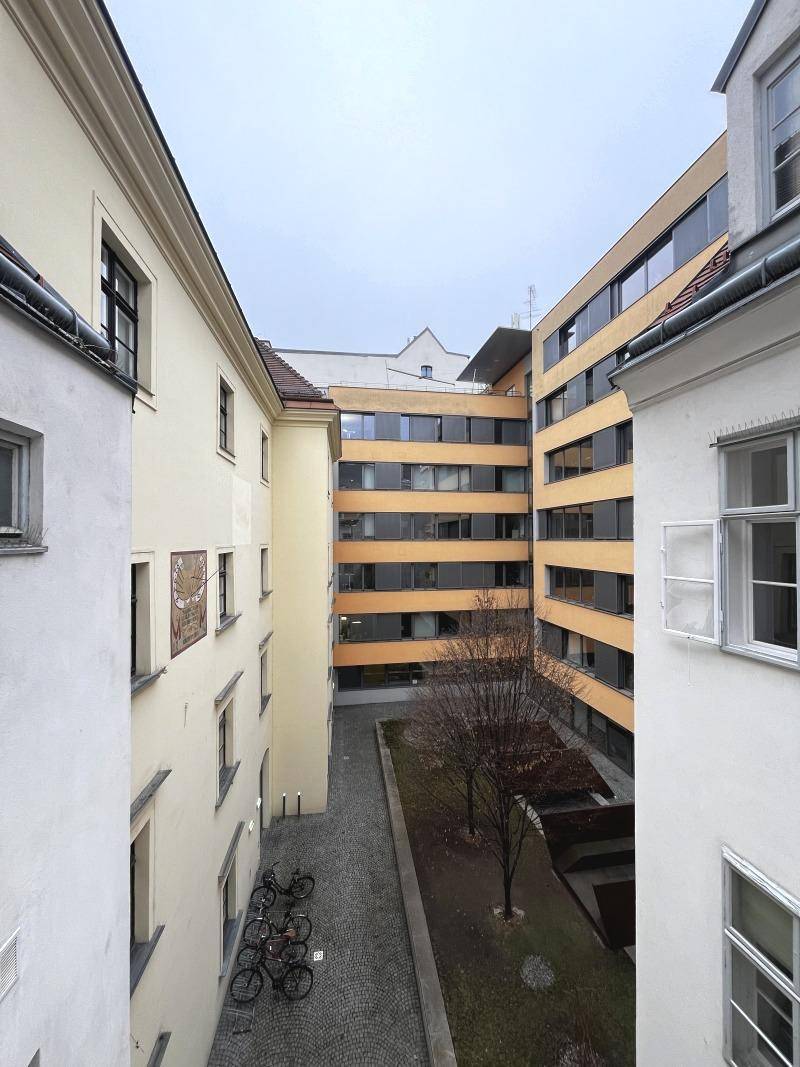 Weitläufiger Blick in den Innenhof, umgeben von historischen und modernen Gebäudefassaden.