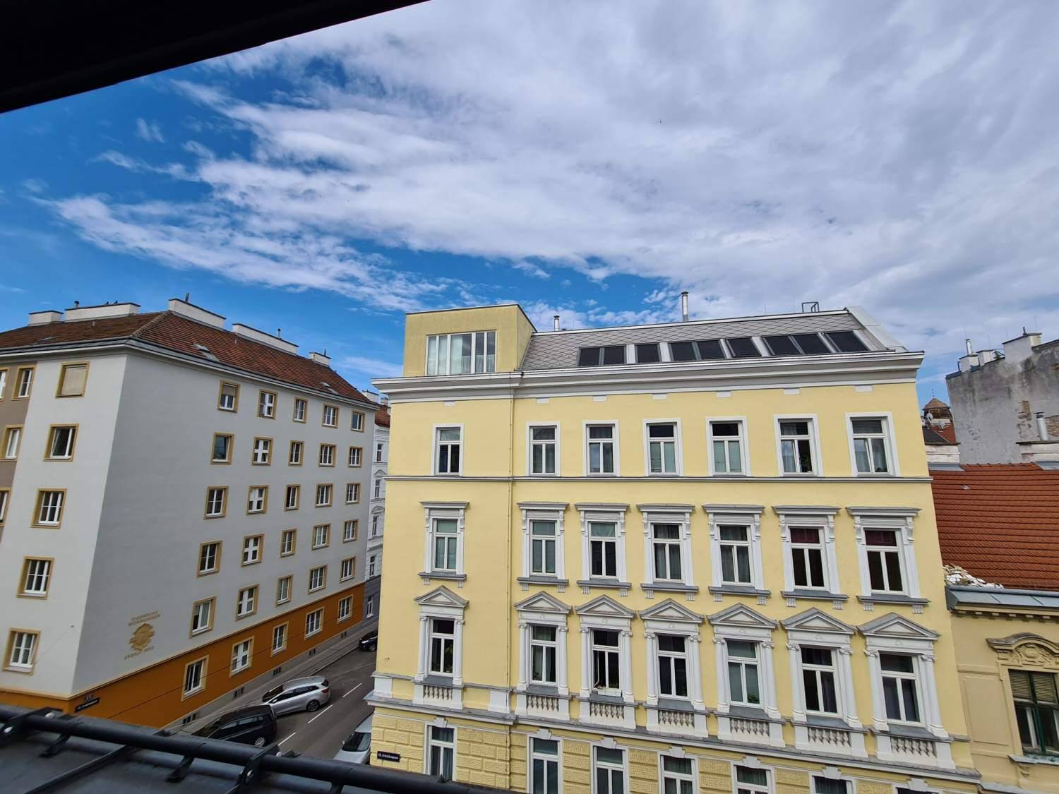 Blick auf die umliegenden Gebäude und die Straße von einem oberen Stockwerk.