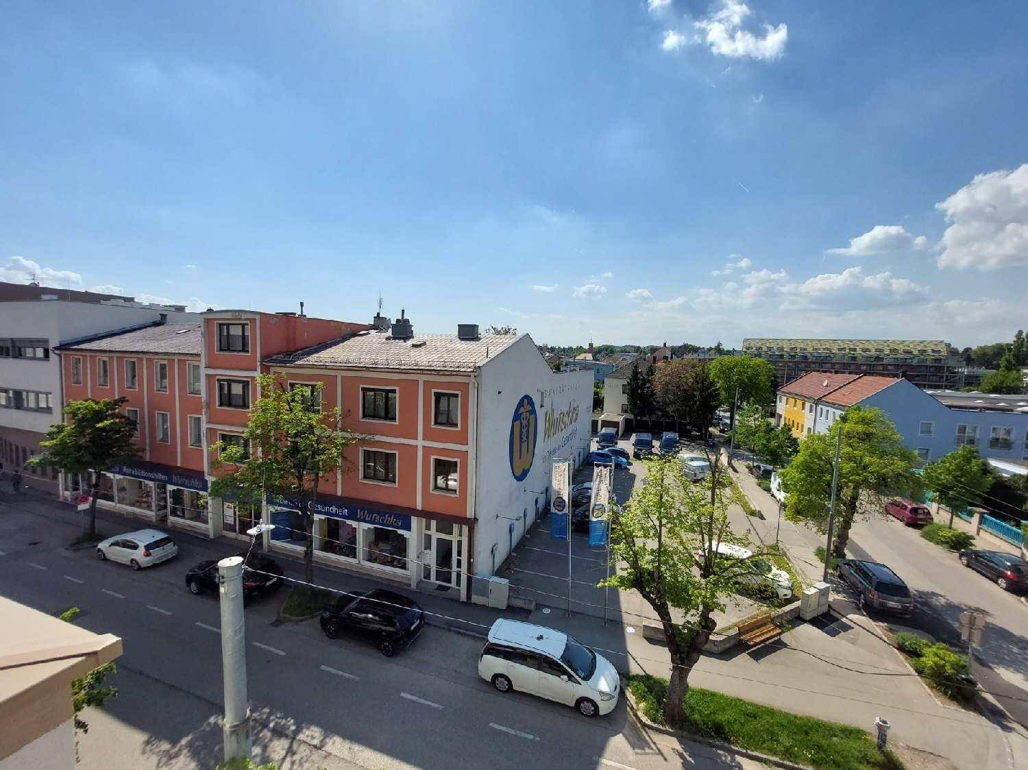 Weitblick über die Stadt mit Gebäuden und einer Straße unter blauem Himmel.