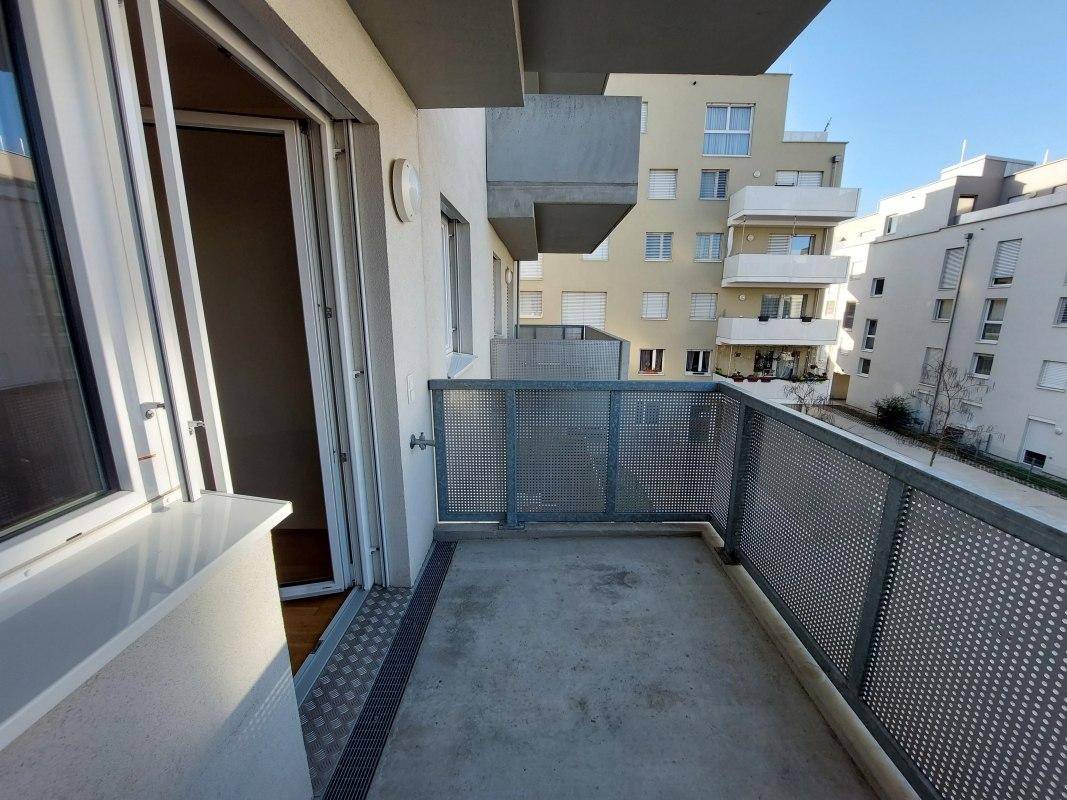 Heller Balkon mit Metallgeländer und Blick auf die umliegenden Gebäude, ideal für entspannte Stunden.