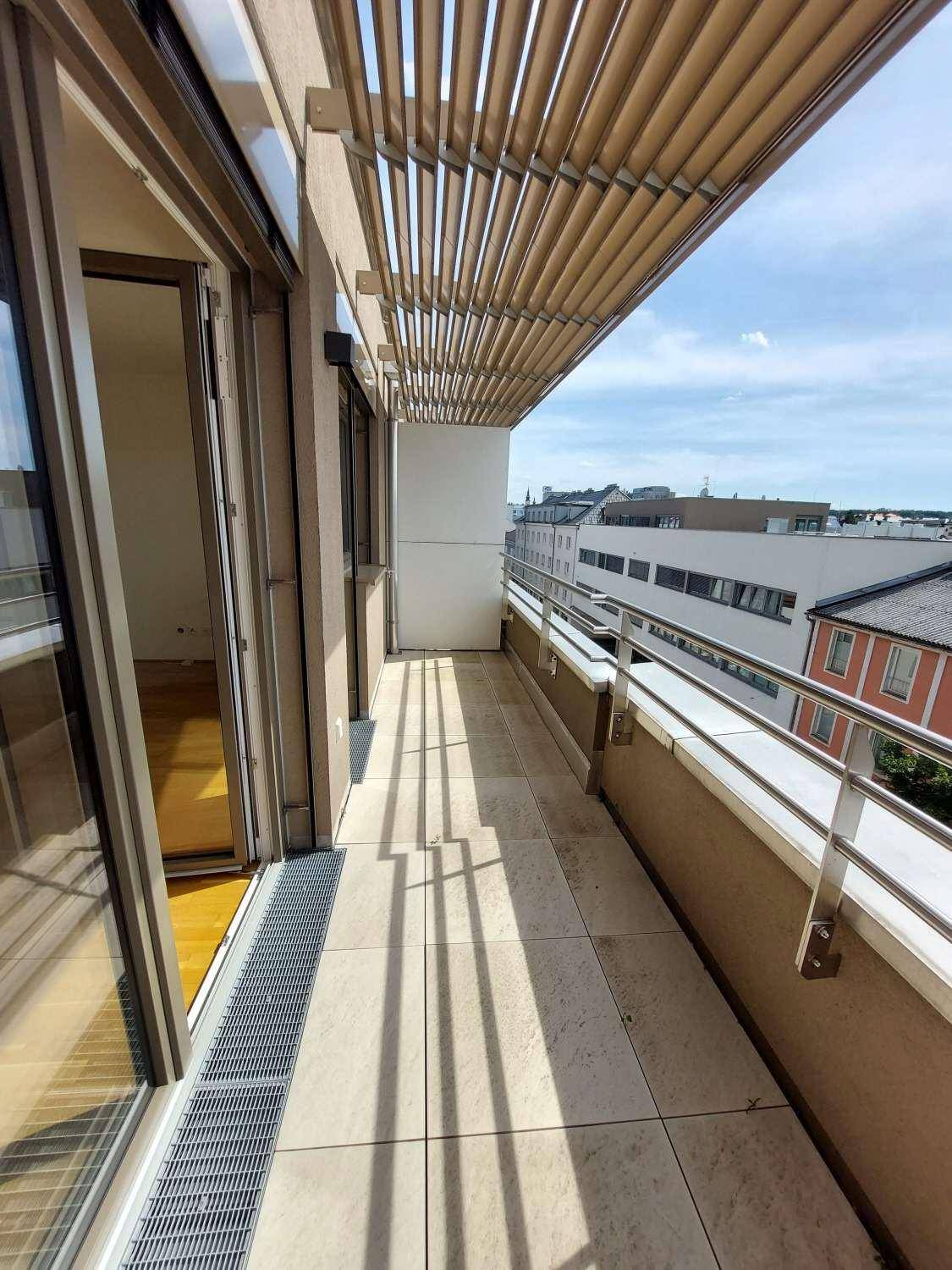 Geräumiger Balkon mit Fliesenboden und Sonnenschutz, ideal für Entspannung.