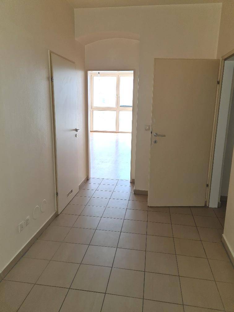 Heller Flur mit Fliesenboden und Zugang zu verschiedenen Wohnbereichen der Wohnung.