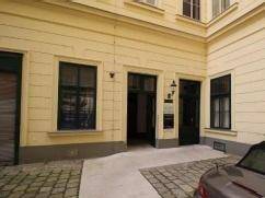 Detailansicht des Eingangs im Innenhof mit Kopfsteinpflaster und einem geparkten Fahrzeug.