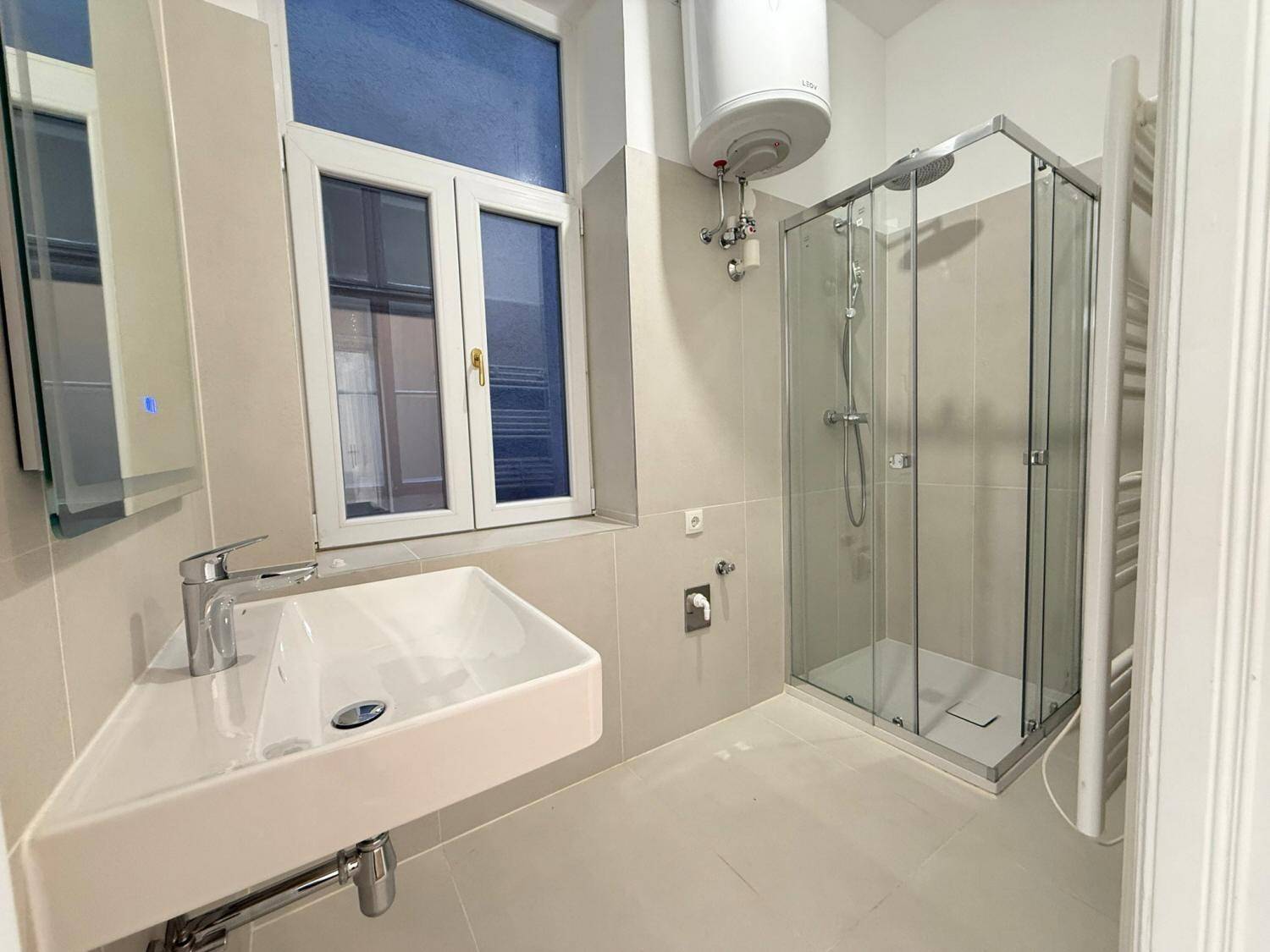 Modernes Badezimmer mit Duschkabine, Eckwaschbecken, beheiztem Handtuchhalter und Fenster.