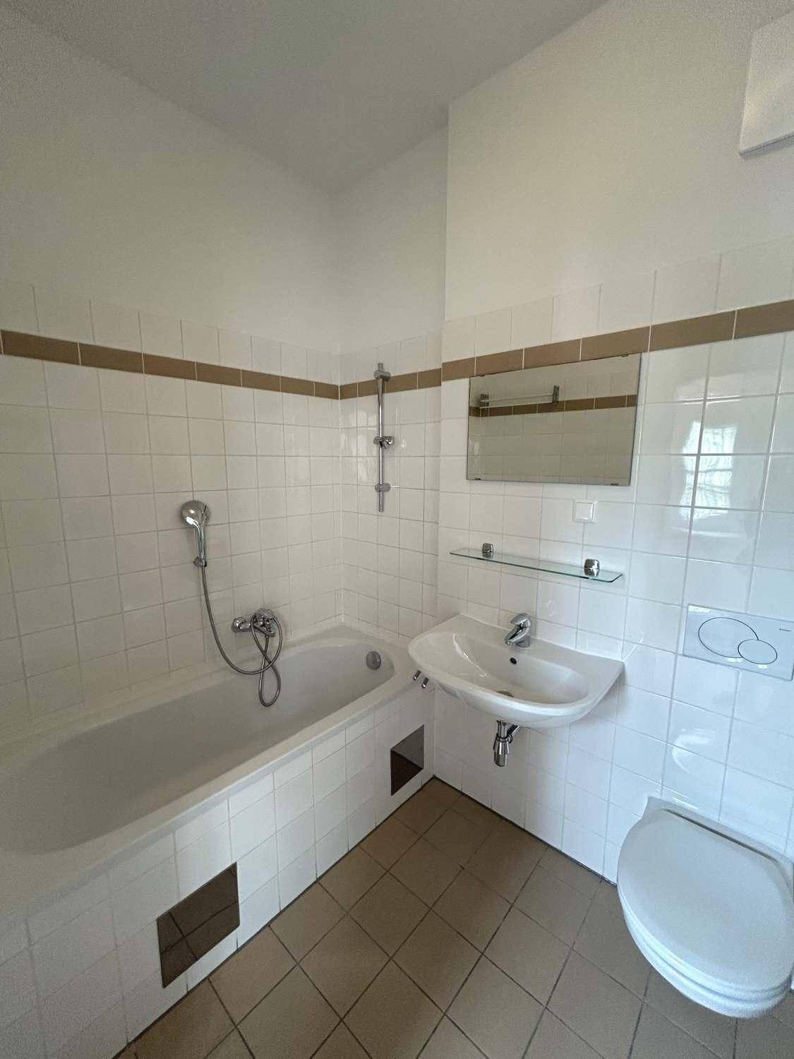 Gefliestes Badezimmer mit Badewanne, Dusche, Waschbecken und Toilette, in gutem, gepflegtem Zustand.