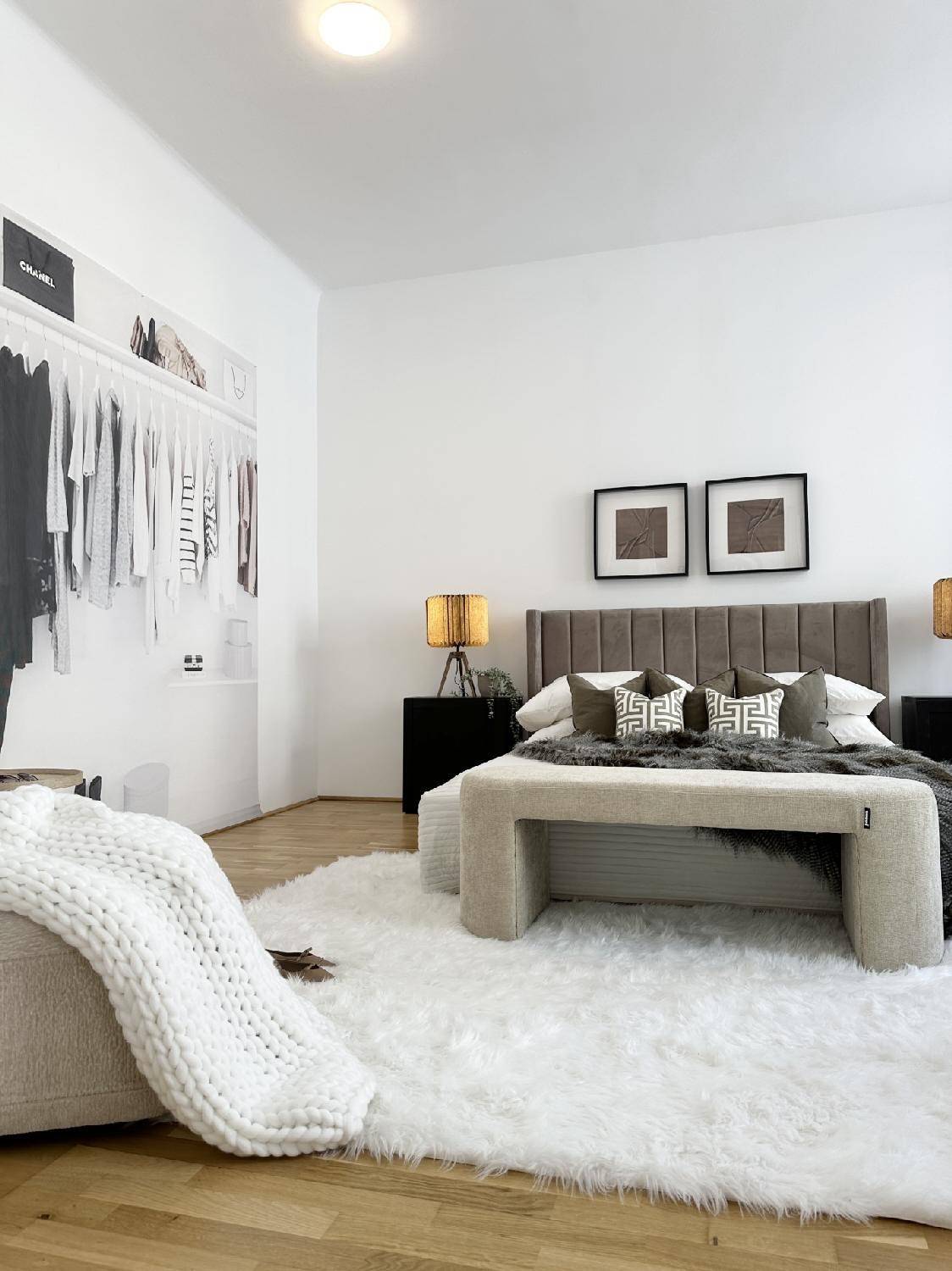 Stilvolles Schlafzimmer mit offenem Kleiderschrank, Holzboden und weichem Teppich, der eine gemütliche Atmosphäre schafft.