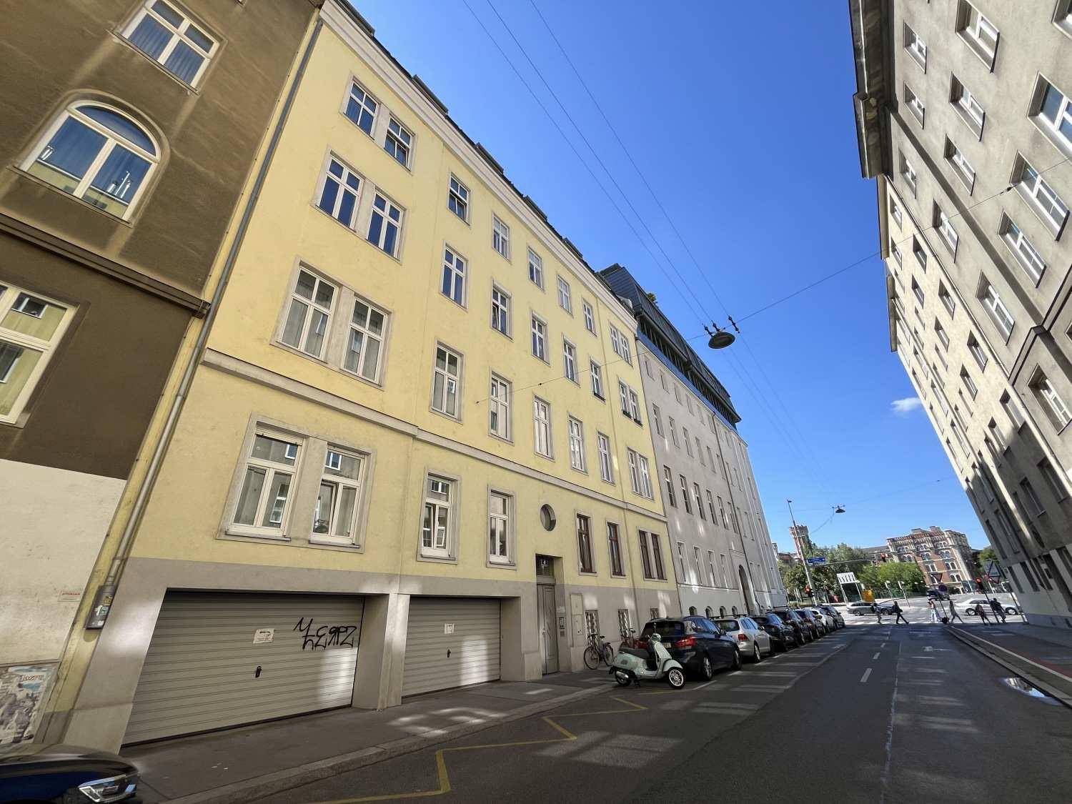Historisches Wohngebäude mit gelber Fassade und Garagenzugang an der Straße, typisch für die Stadt.