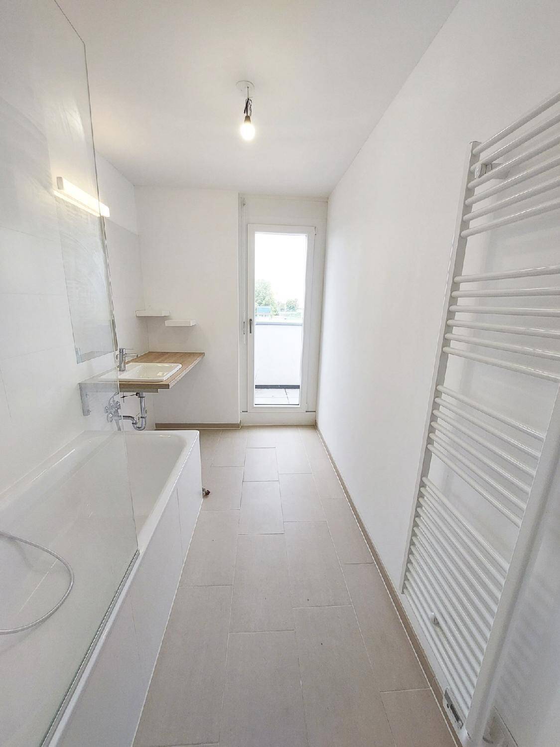 Modernes Badezimmer mit Badewanne, Einzelwaschbecken und beheiztem Handtuchhalter.