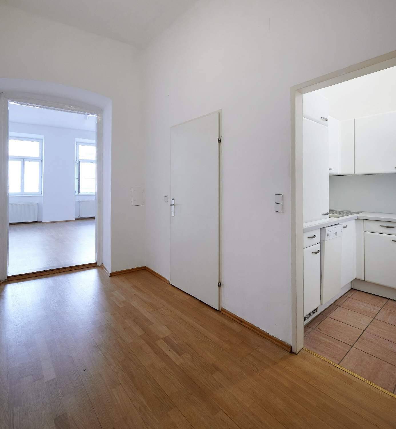 Geräumiger Flur mit Parkettboden, der den Zugang zur Küche und weiteren Zimmern ermöglicht.