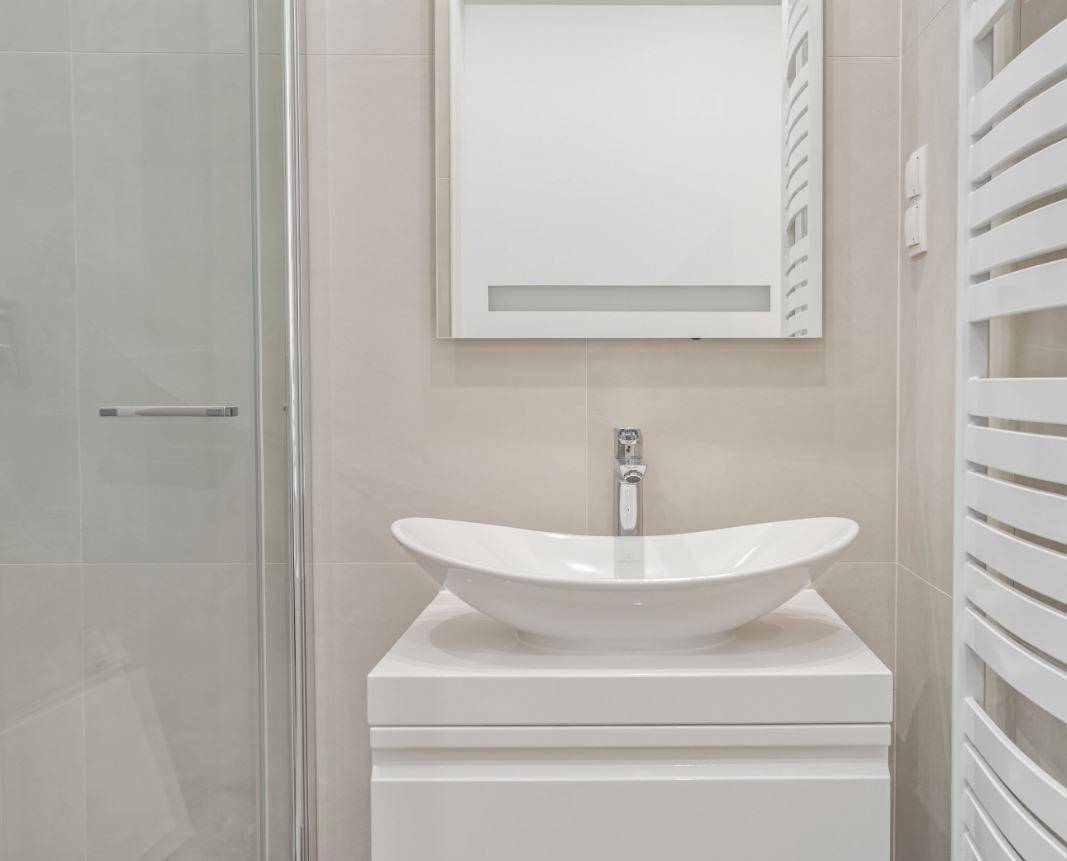 Detailansicht des modernen Badezimmers mit stilvollem Aufsatzwaschbecken und beheiztem Handtuchhalter.