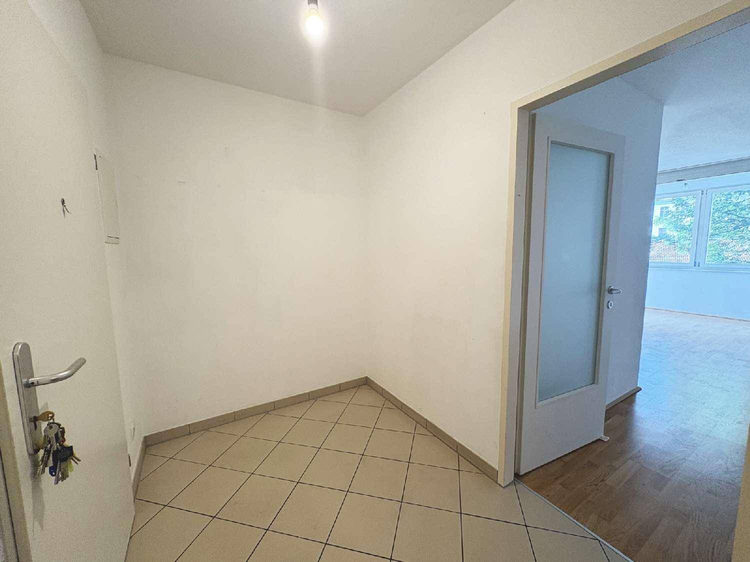 Gefliester Eingangsbereich mit einer Tür und Schlüsseln, die an der Wand hängen.