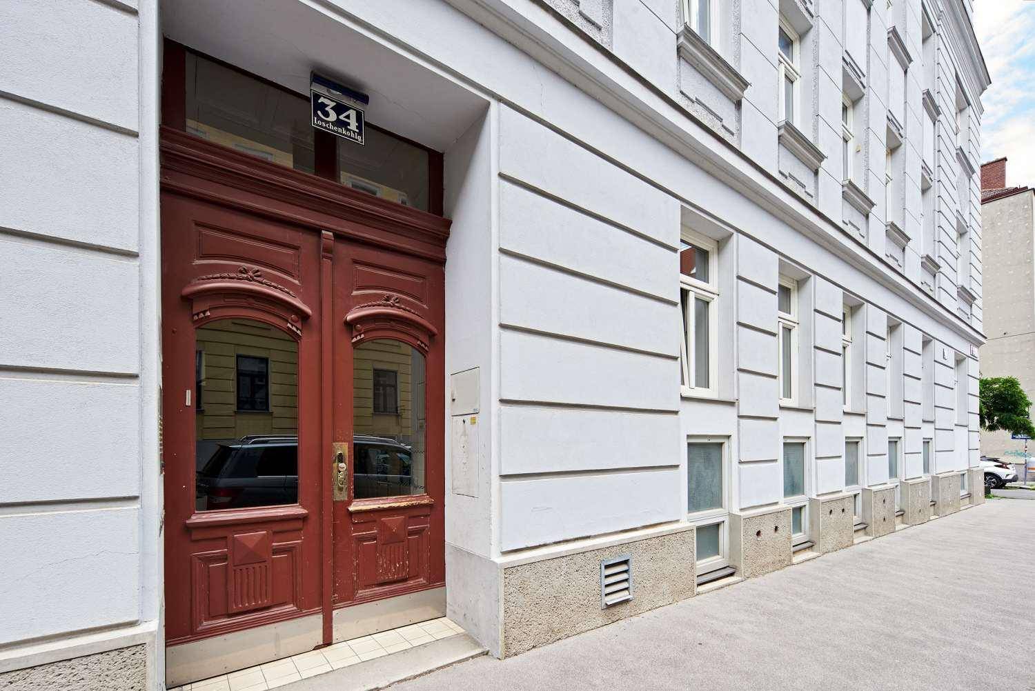 Historische Eingangstür aus Holz mit Hausnummer 34 und klassischer Fassade.
