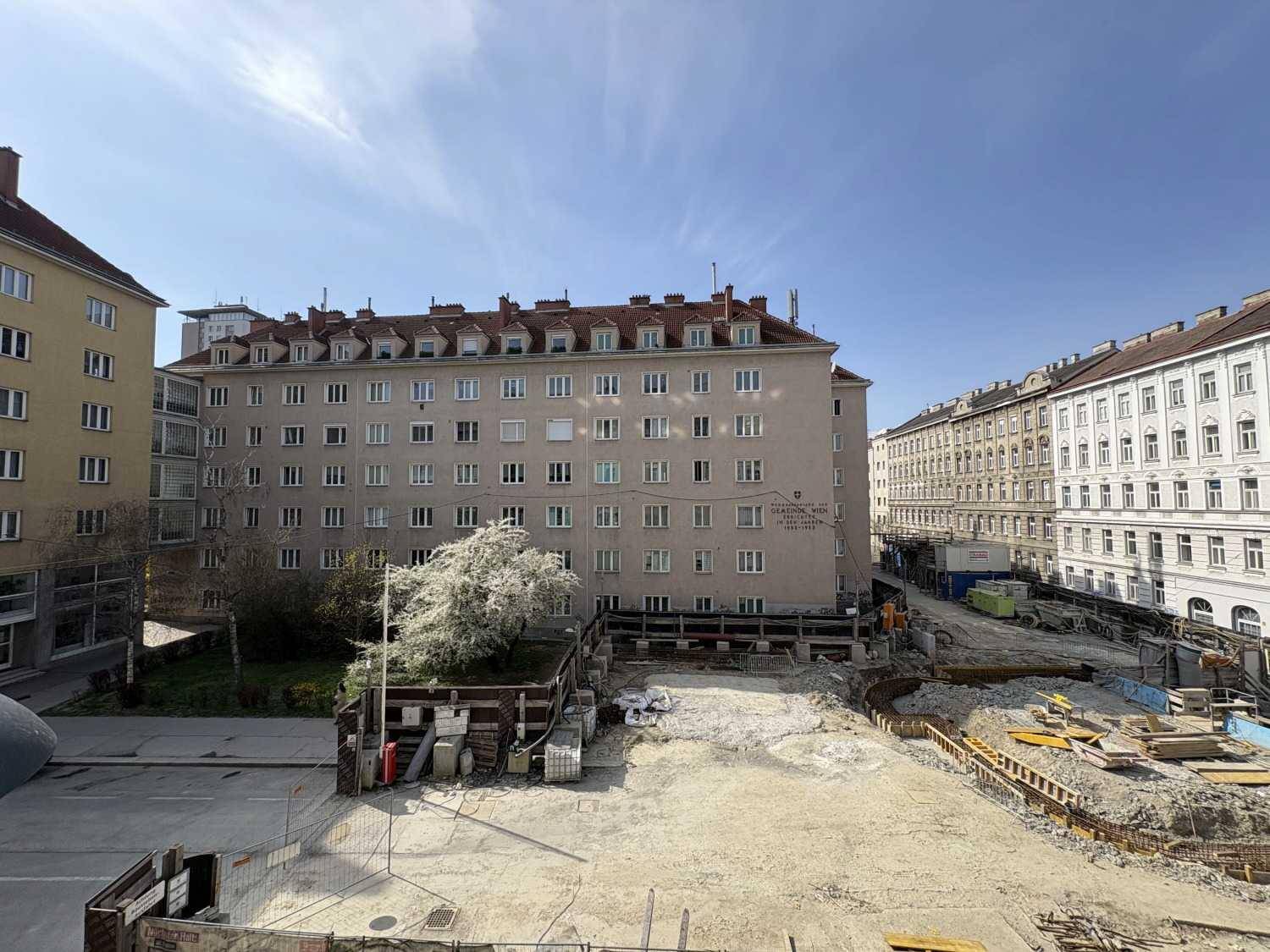 Blick auf umliegende Gebäude und eine Baustelle, die die städtische Entwicklung zeigt.
